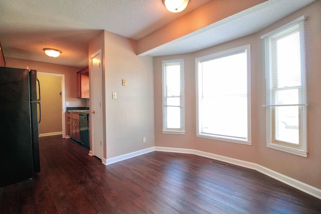 587 Joshua Dr, Clarksville, TN 37042 - unfurnished dining area with dark wood-type flooring, baseboards, healthy amount of natural light, and a textured ceiling