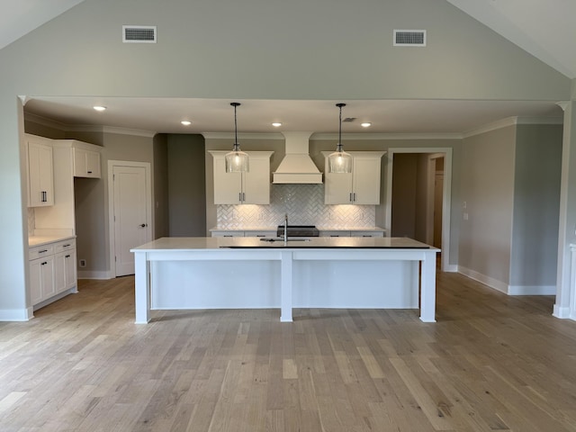 2301 Rockweather Ct, Murfreesboro, TN 37128 - kitchen with custom range hood, vaulted ceiling, backsplash, a center island with sink, and white cabinets