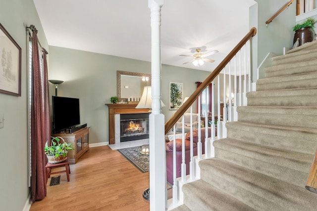 705 W Statue Ct, Franklin, TN 37067 - stairway with a fireplace with flush hearth, wood finished floors, a ceiling fan, and baseboards