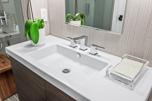 bathroom with wallpapered walls and vanity