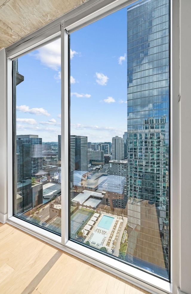 doorway to outside with a city view, wood finished floors, and expansive windows