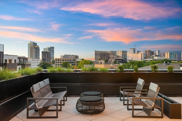 patio terrace at dusk featuring a skyline view