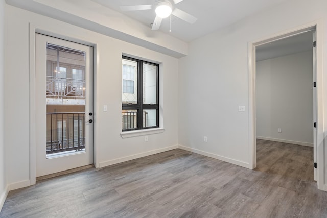 entrance foyer with wood finished floors, a ceiling fan, and baseboards