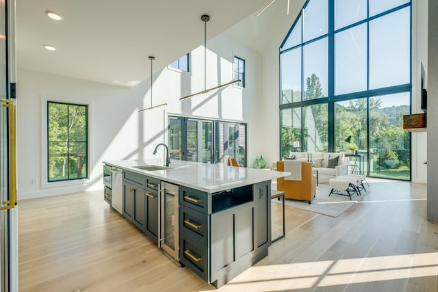 84 Judd Ln, Lancaster, TN 38569 - kitchen featuring a sink, light wood-type flooring, wine cooler, a towering ceiling, and an island with sink