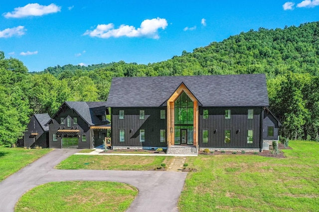 84 Judd Ln, Lancaster, TN 38569 - view of front facade with board and batten siding, a forest view, and a front lawn