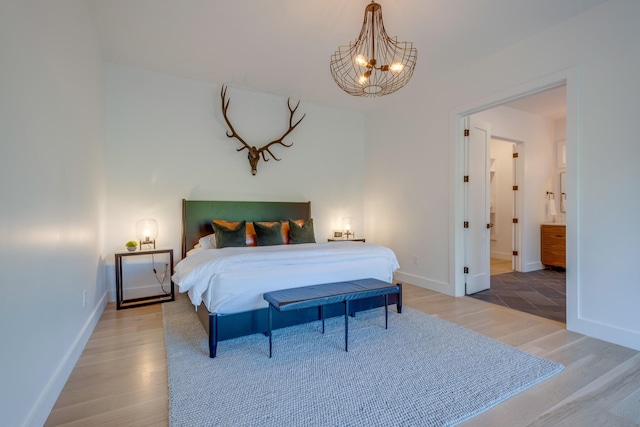 84 Judd Ln, Lancaster, TN 38569 - bedroom featuring light wood-type flooring, a chandelier, baseboards, and ensuite bath