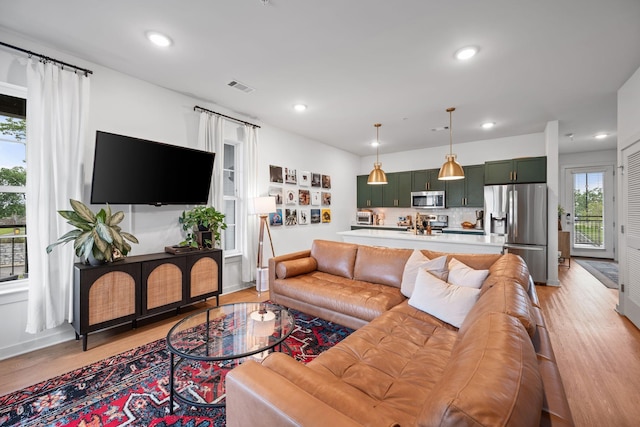 living area with light wood finished floors, recessed lighting, and baseboards