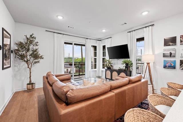 living room with wood finished floors, plenty of natural light, recessed lighting, and baseboards