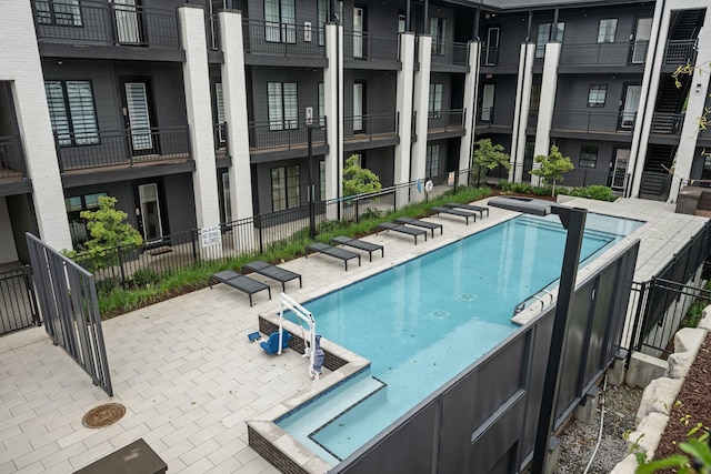 community pool with fence and a patio area