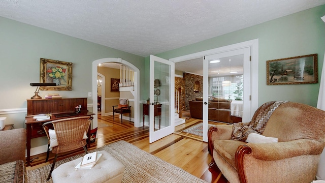 152 Bluegrass Dr, Hendersonville, TN 37075 - living area featuring french doors, arched walkways, light wood-style flooring, a textured ceiling, and baseboards