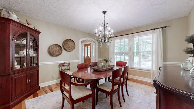 152 Bluegrass Dr, Hendersonville, TN 37075 - dining space featuring arched walkways, light wood-type flooring, a chandelier, a textured ceiling, and baseboards