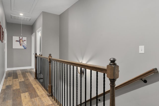 hallway with attic access, an upstairs landing, wood finished floors, and baseboards