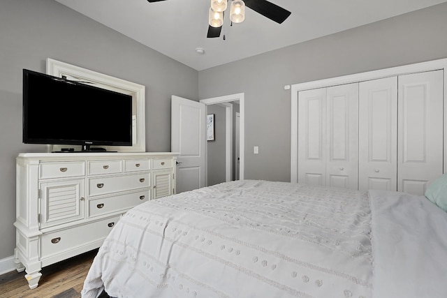 bedroom with dark wood-style flooring, a closet, a ceiling fan, and baseboards