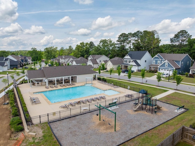 community pool featuring a residential view, fence, and a patio area