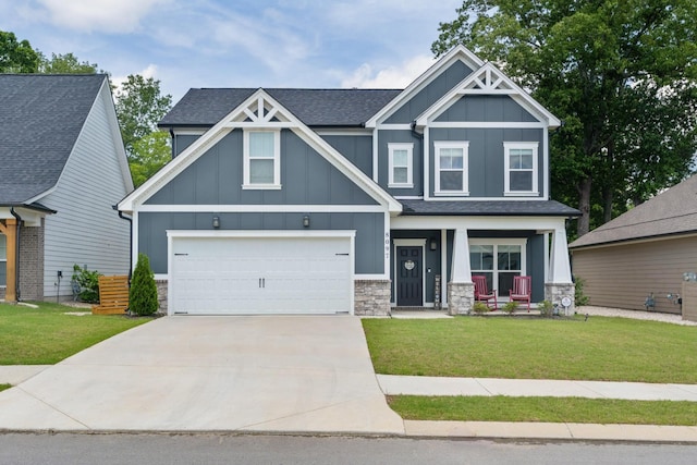 craftsman-style home with board and batten siding, a porch, concrete driveway, a front lawn, and stone siding