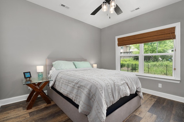 bedroom featuring baseboards, wood finished floors, and a ceiling fan