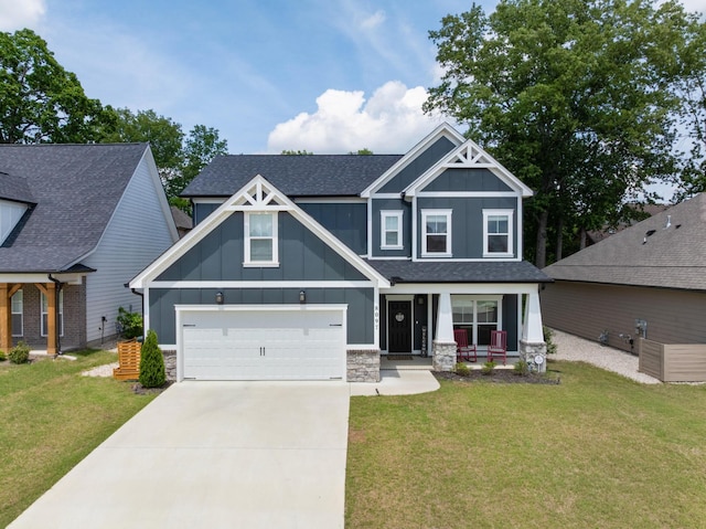 craftsman-style house with board and batten siding, driveway, covered porch, and a front yard