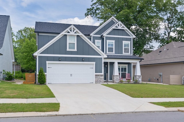 craftsman-style home with board and batten siding, concrete driveway, a front yard, and roof with shingles