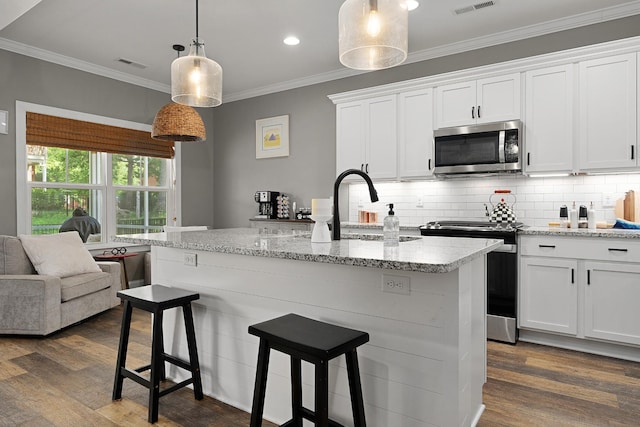kitchen featuring appliances with stainless steel finishes, ornamental molding, dark wood-style floors, white cabinets, and decorative backsplash