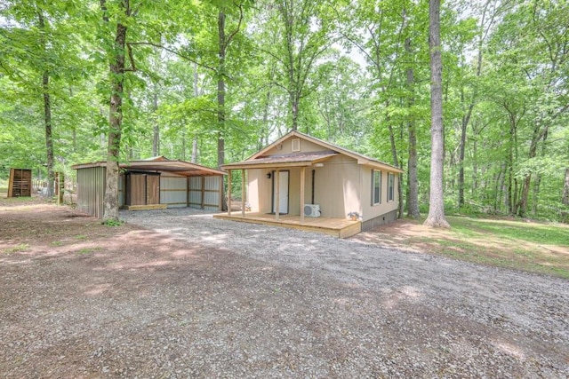 view of front of house with a detached carport, driveway, and crawl space