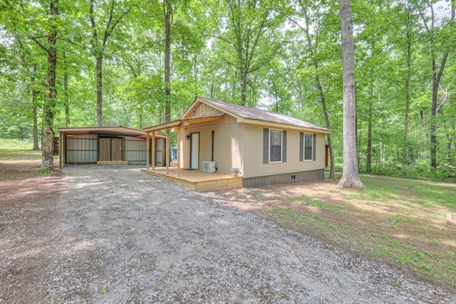 view of front of home featuring a detached carport, crawl space, an outbuilding, and driveway