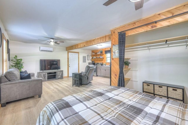 bedroom featuring an AC wall unit, light wood-style flooring, and a ceiling fan