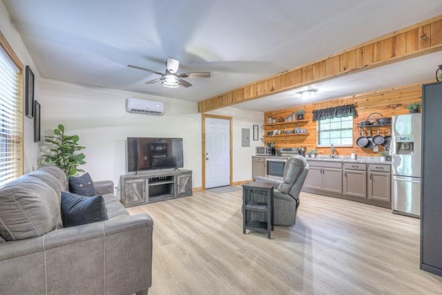 living area featuring a wall mounted air conditioner, light wood-style floors, ceiling fan, and wooden walls