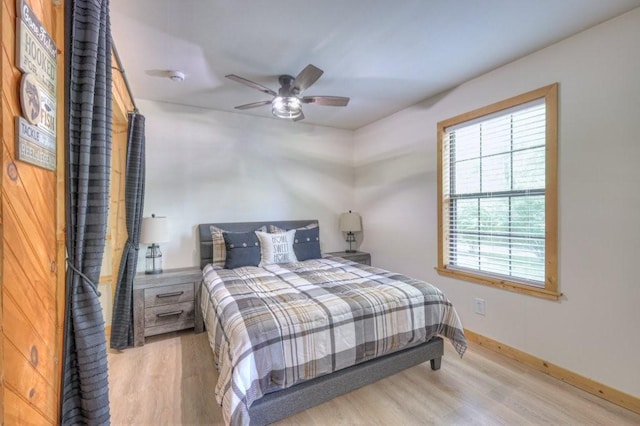 bedroom featuring light wood-style floors, baseboards, and ceiling fan