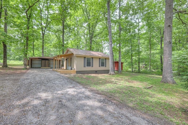 ranch-style home with dirt driveway, a carport, and crawl space
