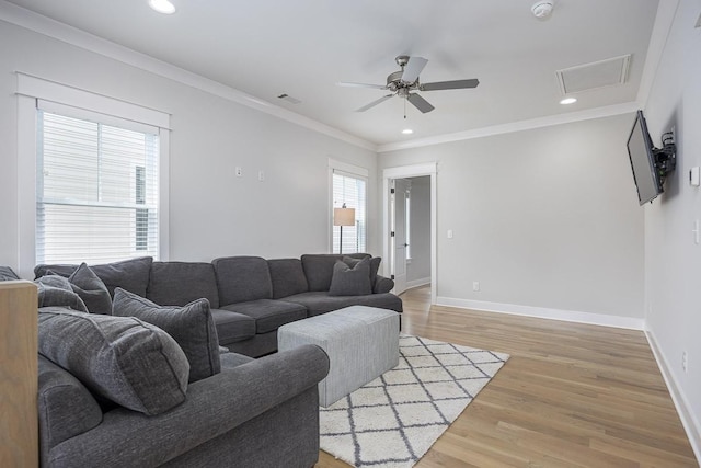 living area featuring a ceiling fan, baseboards, light wood-type flooring, recessed lighting, and crown molding