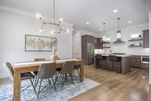 dining room featuring crown molding, wood finished floors, recessed lighting, a chandelier, and baseboards