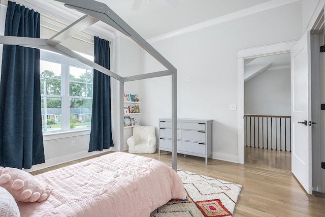 bedroom featuring wood finished floors, baseboards, and vaulted ceiling