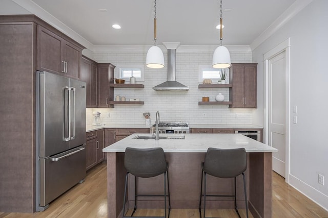 kitchen with open shelves, high end refrigerator, wall chimney exhaust hood, crown molding, and light wood-type flooring
