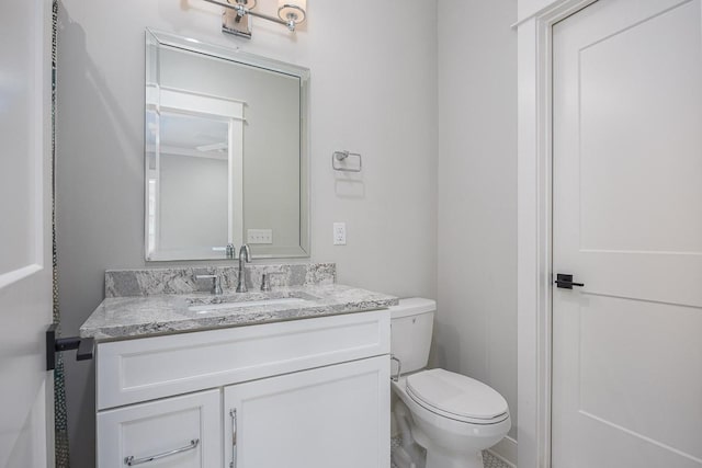 half bath featuring vanity and toilet