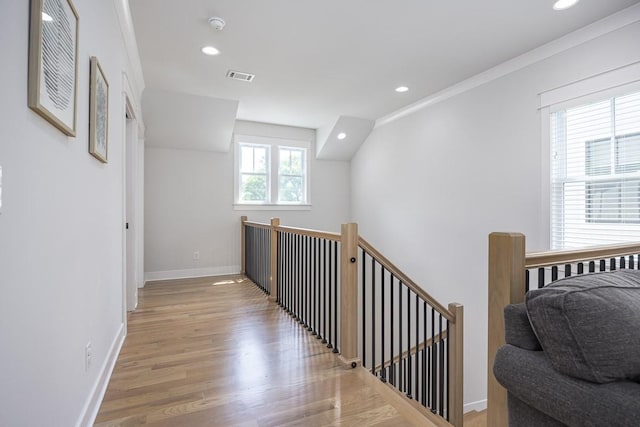hallway with light wood-type flooring, baseboards, an upstairs landing, and recessed lighting