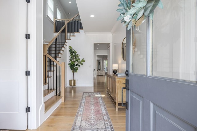 foyer with stairs, light wood-style floors, ornamental molding, and recessed lighting