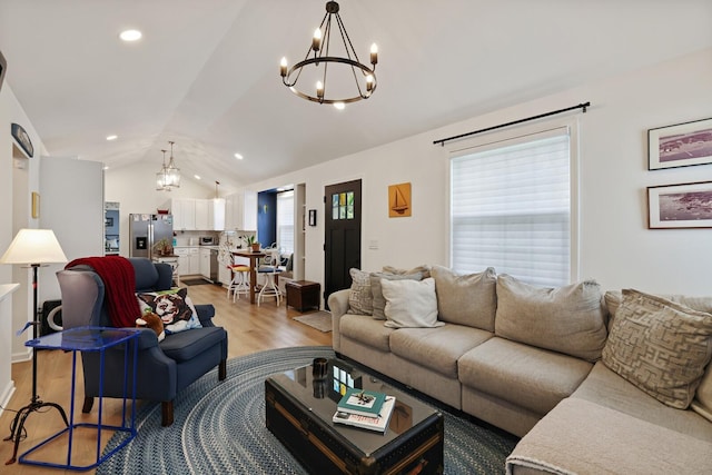 living area with a chandelier, light wood-style floors, vaulted ceiling, and recessed lighting
