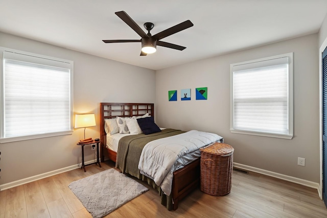 bedroom with wood finished floors, baseboards, and a ceiling fan