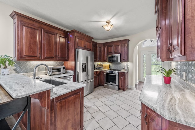 4484 N Pinson Rd, Portland, TN 37148 - kitchen with appliances with stainless steel finishes, a peninsula, a sink, tasteful backsplash, and light stone countertops