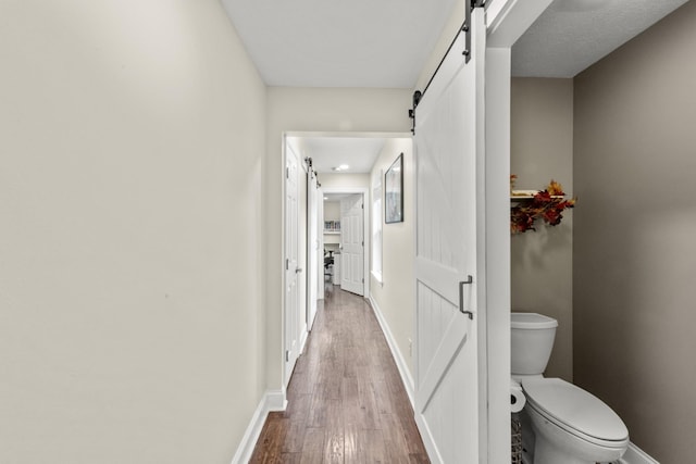 4484 N Pinson Rd, Portland, TN 37148 - hallway with a barn door, wood finished floors, and baseboards
