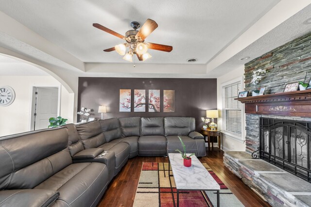 4484 N Pinson Rd, Portland, TN 37148 - living area featuring a tray ceiling, arched walkways, a ceiling fan, a fireplace, and wood finished floors