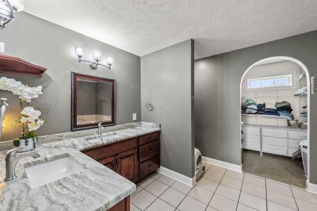 4484 N Pinson Rd, Portland, TN 37148 - bathroom with tile patterned floors, a textured ceiling, vanity, baseboards, and a spacious closet