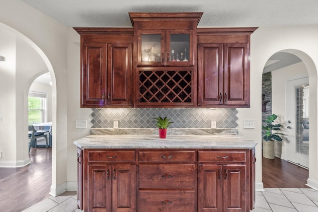 4484 N Pinson Rd, Portland, TN 37148 - indoor wet bar featuring backsplash, arched walkways, light wood-style flooring, and baseboards