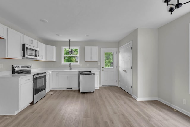 kitchen featuring stainless steel appliances, light wood-style floors, light countertops, and white cabinets
