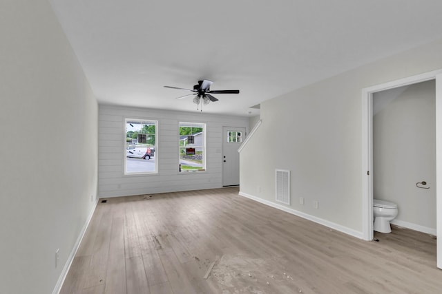 unfurnished living room featuring ceiling fan, baseboards, and wood finished floors