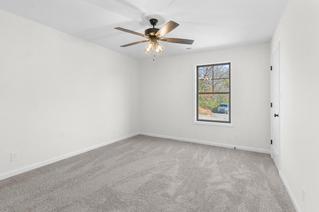 carpeted empty room featuring ceiling fan and baseboards