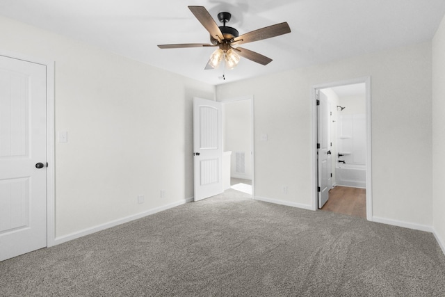 unfurnished bedroom with carpet flooring, baseboards, ensuite bathroom, and a ceiling fan