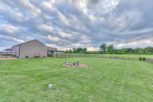 view of yard with a pole building, a fire pit, an outbuilding, and a view of rural / pastoral area