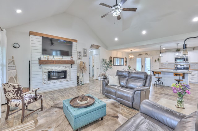 living area with ceiling fan, vaulted ceiling, light wood finished floors, french doors, and recessed lighting