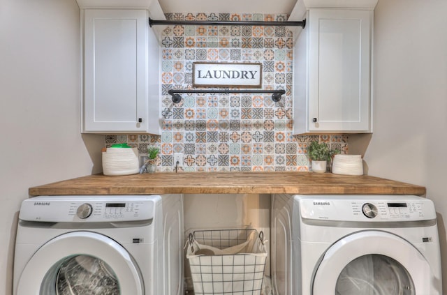 laundry room with washing machine and clothes dryer and cabinet space